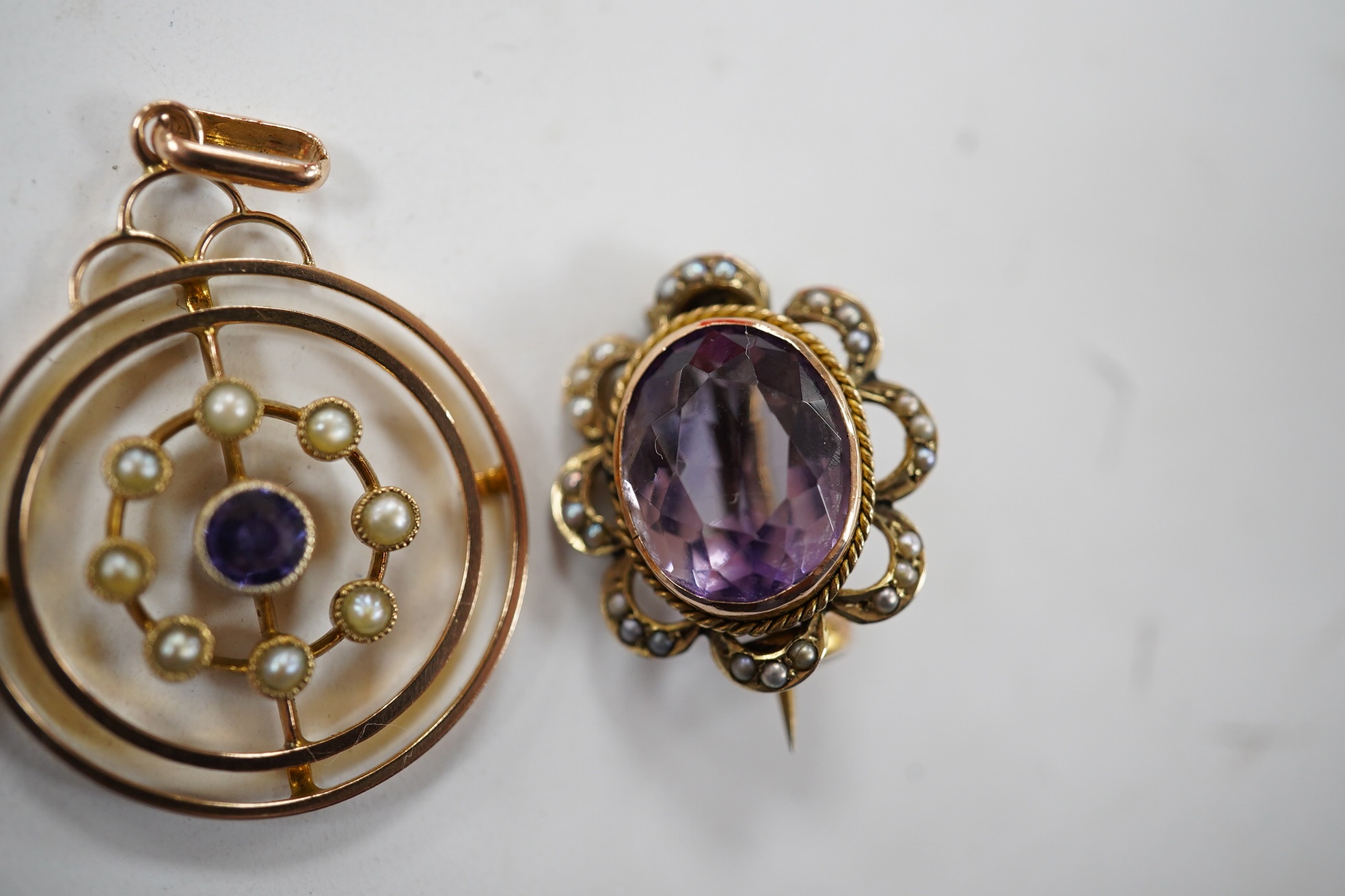 An Edwardian 9ct, sapphire and seed pearl cluster set open work circular pendant, 26mm, together with a similar 9ct, amethyst and seed pearl set brooch and a 9ct and nephrite set brooch, gross weight 7.4 grams. Condition